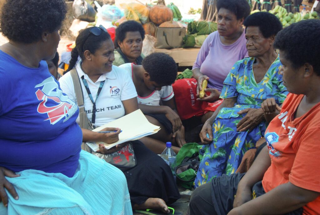 Sereima speaking with women at the market