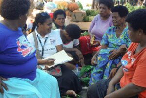 Sereima speaking with women at the market